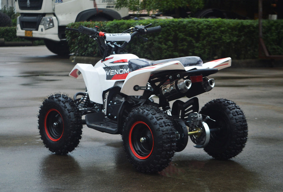 49cc Mini Quad ATV in red/white combo parked diagonally facing its rear to the left revealing dual exhaust pipes and free matching rims in red