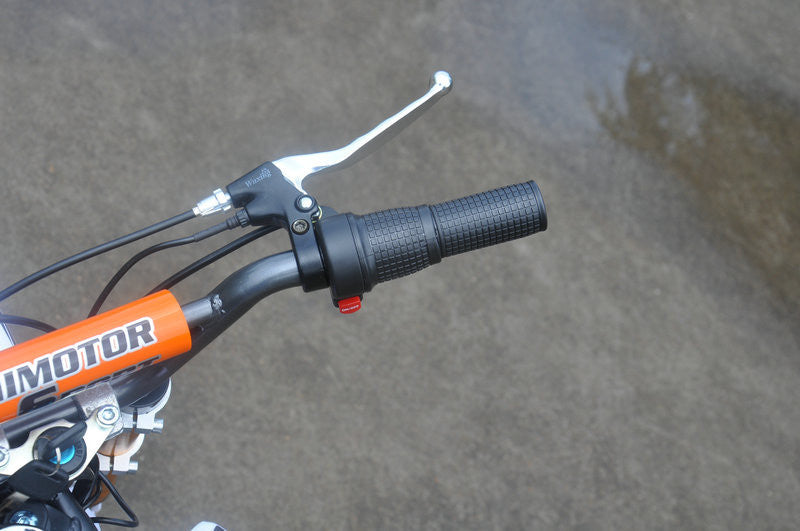 Close up of right throttle handle of Orange and white fully electric dirt bike 500 watts 24 volts with on/off button and right hand brake revealed